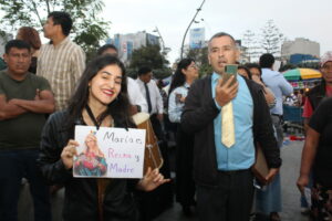 Una protestante levanta un cartel con un mensaje de aceptación religiosa y de la comunidad LGBTIQ+ al lado de protestantes religiosos en contra de la marcha